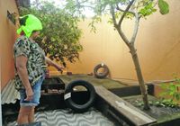 Dona de casa aponta para água acumula em pneus velhos, no quintal de casa, um dos principais focos do mosquito transmissor da doença